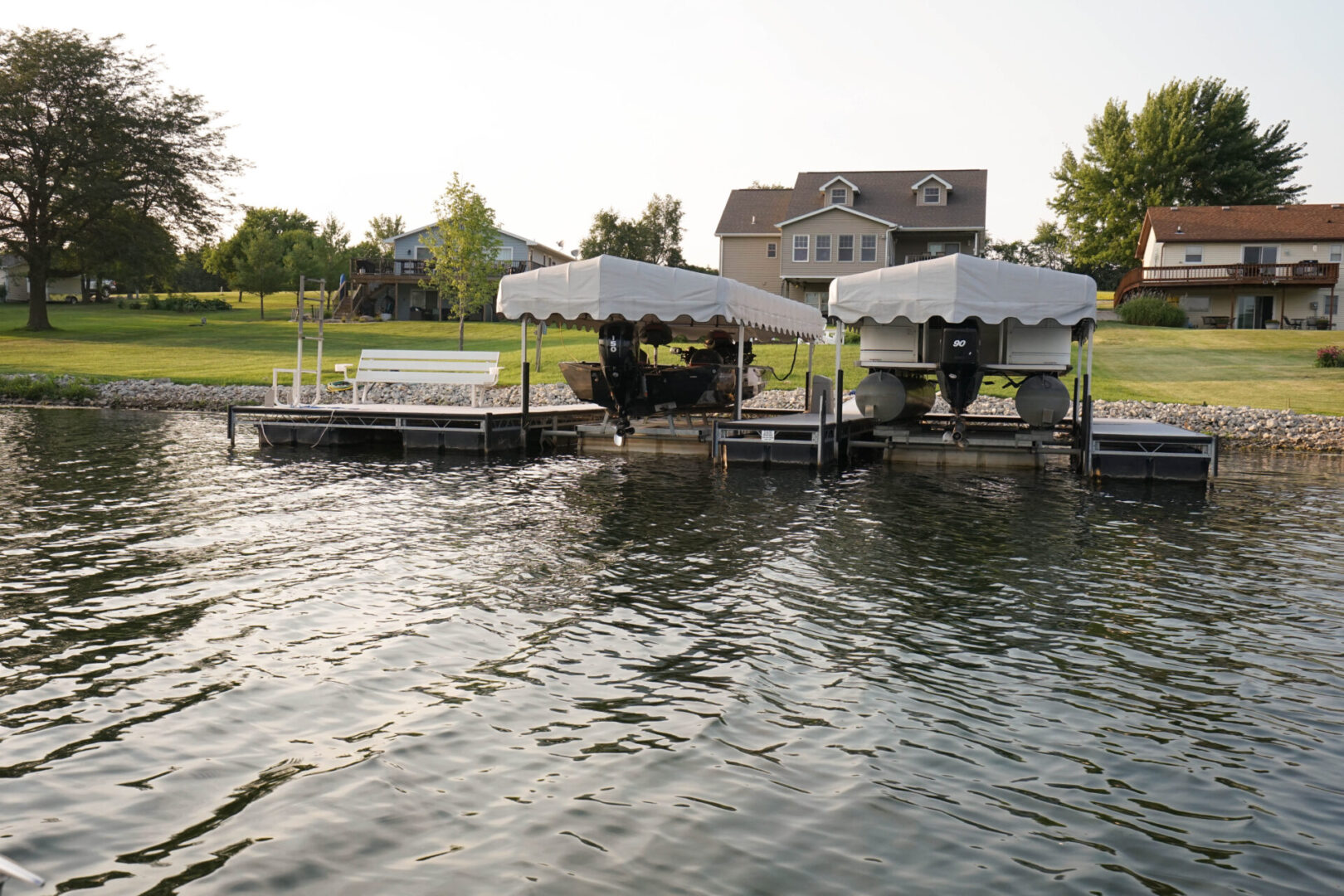 A dock with several white umbrellas on the water.