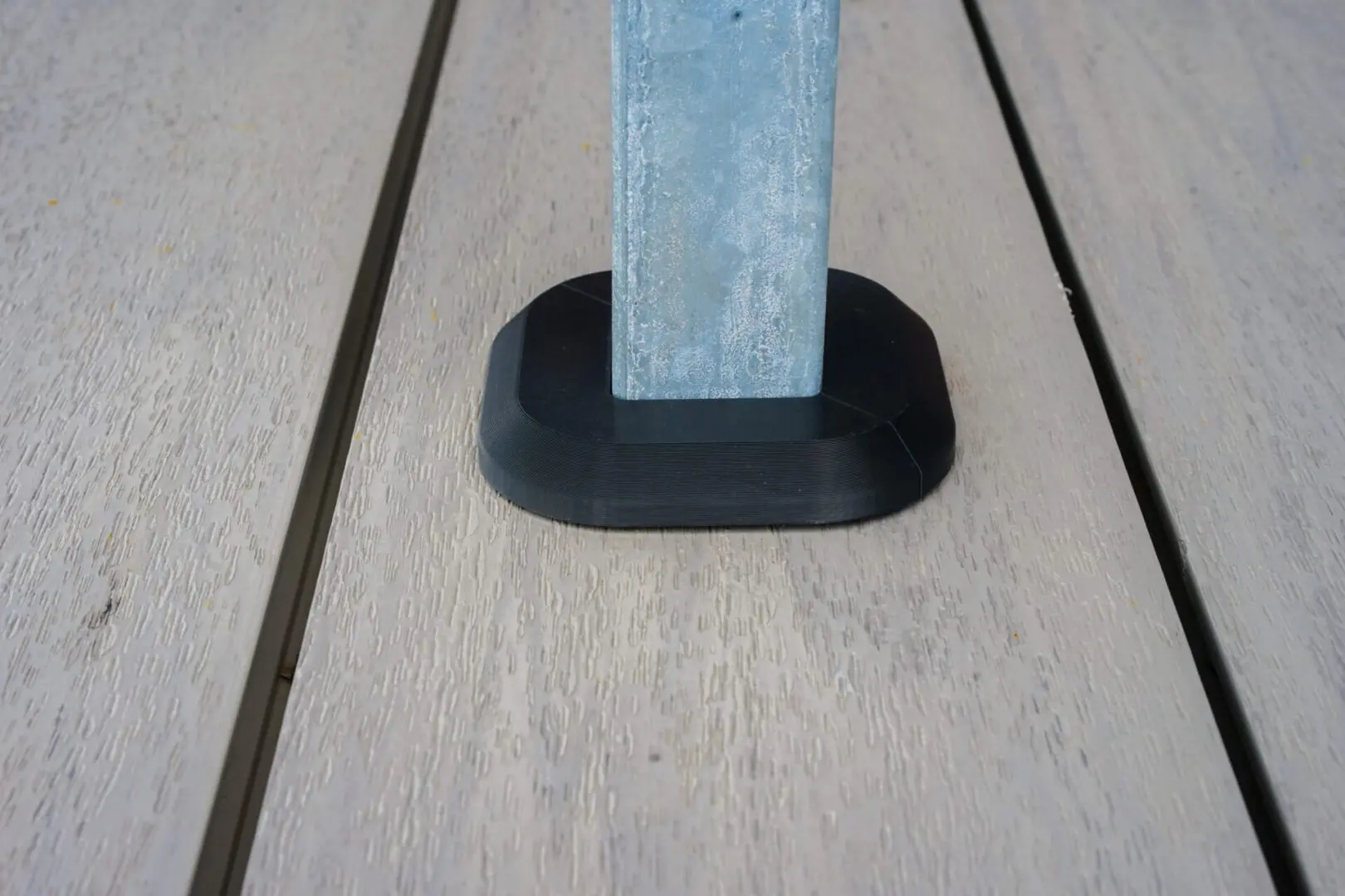 Here's an alt tag for the image: Metal post on black base on deck.