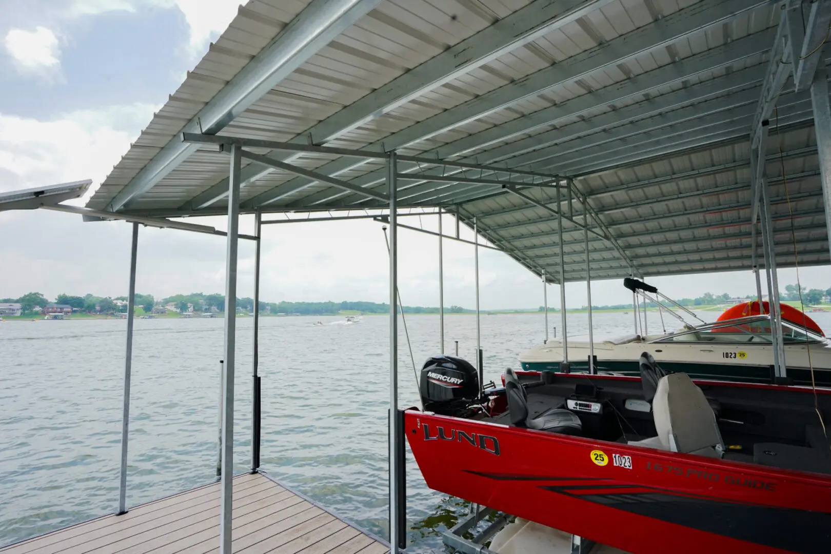 Boat dock with covered slips on lake.