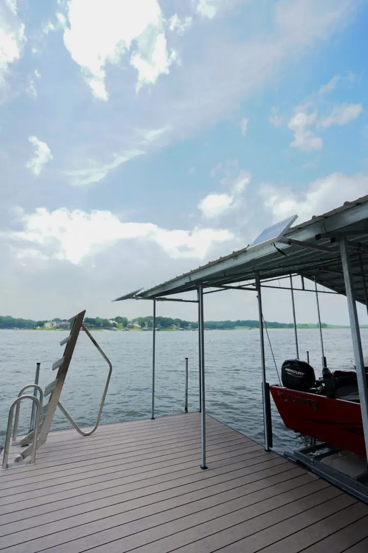 Here's an alt tag for the image: Lake dock with boat and solar panel.