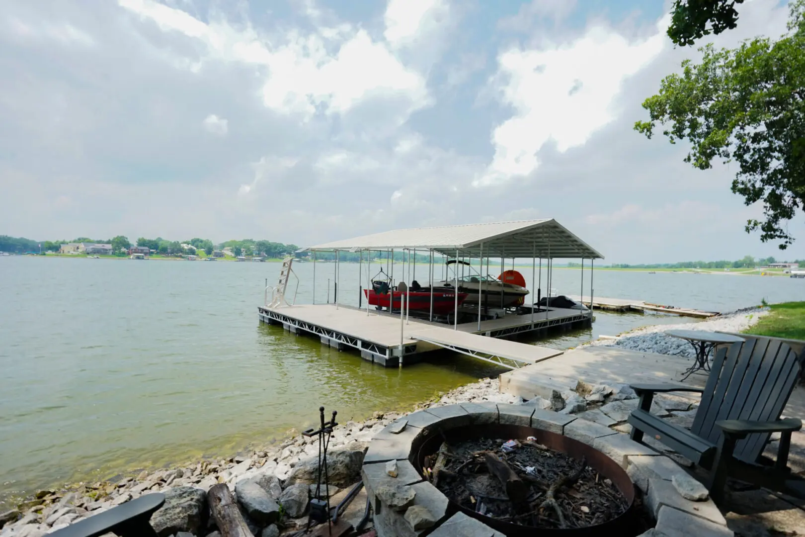 Lakefront dock with boats and fire pit.