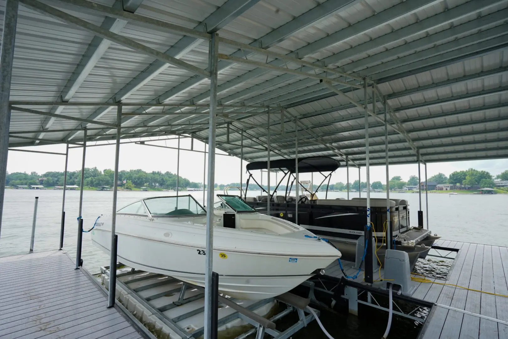 Boats sheltered under a dock canopy.