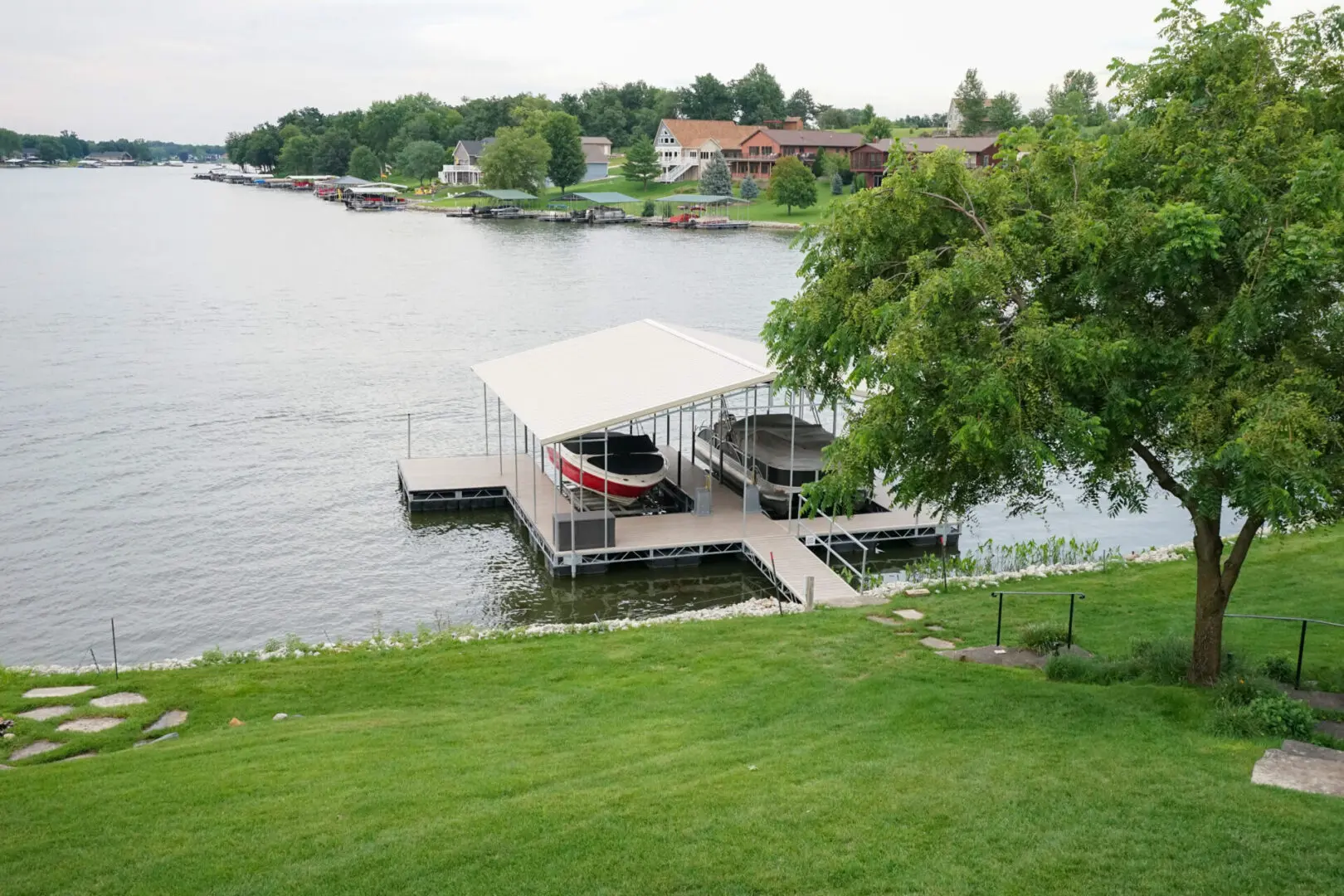Here's a short alt tag for the image: Lakefront dock with boats under cover.